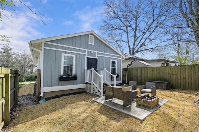 back of house featuring a patio area, fence, and a fire pit