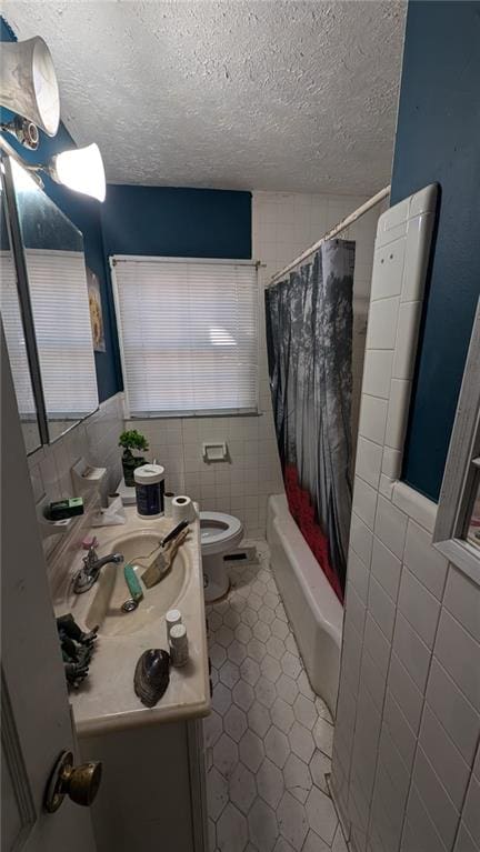 full bathroom with vanity, toilet, tile walls, and shower / bath combination with curtain