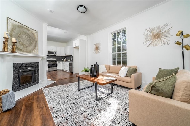 living room featuring a high end fireplace, dark wood-type flooring, and ornamental molding