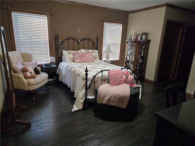 bedroom with dark wood-style floors, ornamental molding, and multiple windows