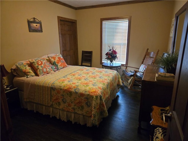 bedroom with ornamental molding and wood finished floors