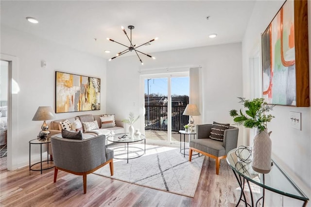 living room featuring light wood-type flooring and a notable chandelier