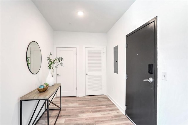 hall featuring electric panel and light hardwood / wood-style floors