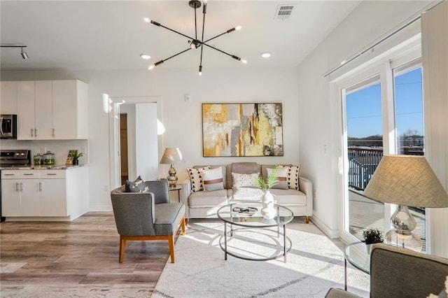 living room featuring light hardwood / wood-style floors and a notable chandelier