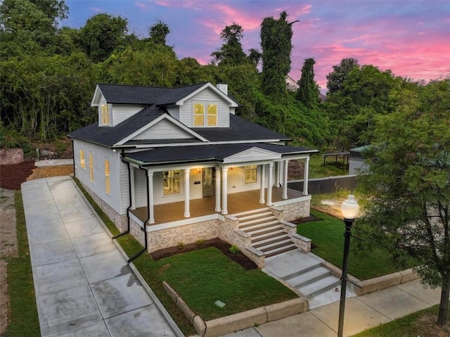 view of front of home with a porch and a yard