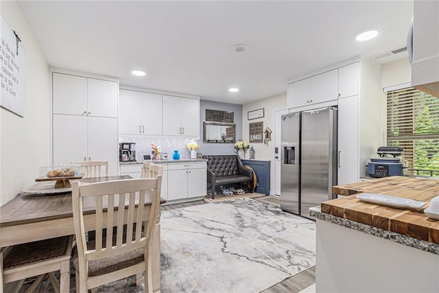 1549 Miller Valley Dr, Bethlehem, GA 30620 - kitchen with stainless steel refrigerator with ice dispenser, light wood-style floors, white cabinetry, wooden counters, and recessed lighting