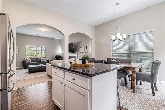 1549 Miller Valley Dr, Bethlehem, GA 30620 - kitchen featuring arched walkways, freestanding refrigerator, dark wood-type flooring, white cabinetry, and a chandelier