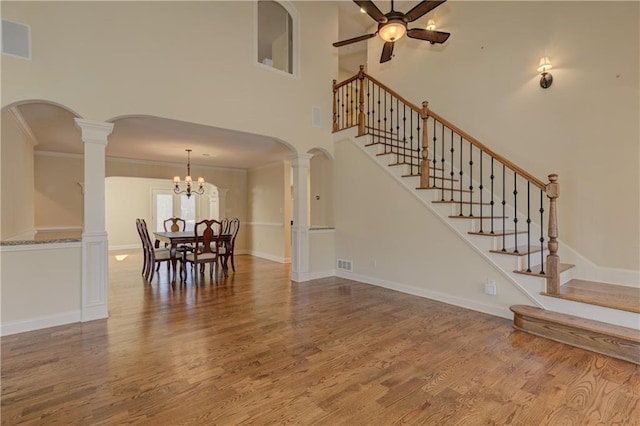 interior space featuring visible vents, decorative columns, wood finished floors, and arched walkways