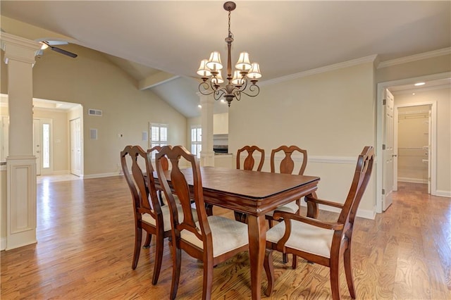 dining area featuring decorative columns, baseboards, light wood-style floors, and vaulted ceiling