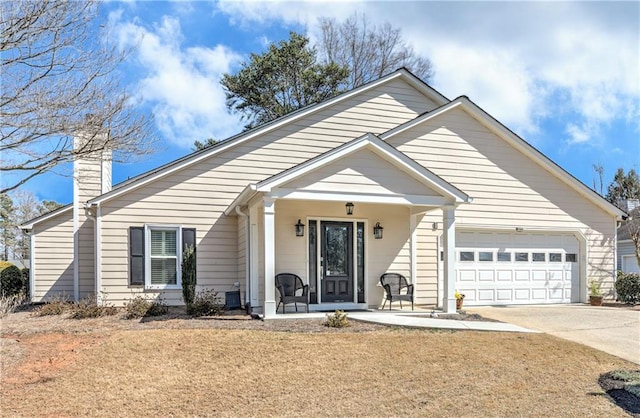 view of front of property with concrete driveway, a front yard, covered porch, a chimney, and an attached garage