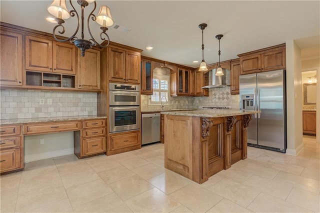 kitchen featuring light stone counters, appliances with stainless steel finishes, brown cabinetry, and a sink