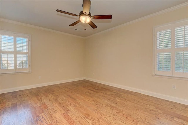 spare room with visible vents, ornamental molding, a ceiling fan, light wood-style floors, and baseboards