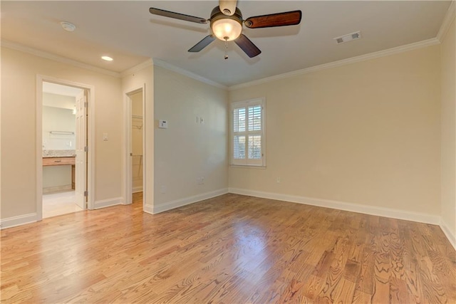 spare room featuring crown molding, visible vents, and light wood finished floors