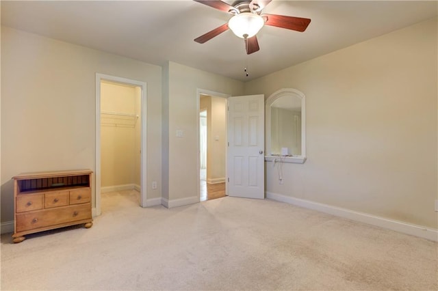 unfurnished bedroom with a spacious closet, carpet flooring, baseboards, and a closet