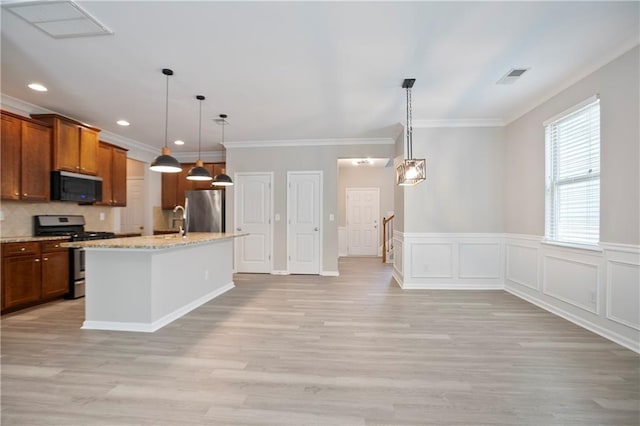 kitchen with appliances with stainless steel finishes, light wood-style flooring, ornamental molding, a sink, and backsplash