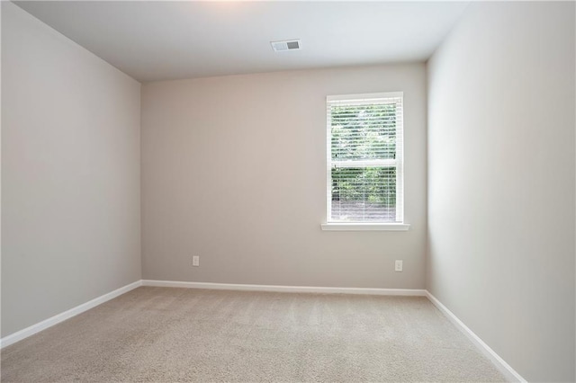 unfurnished room with baseboards and light colored carpet