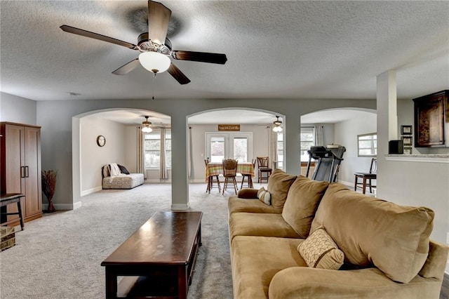 carpeted living room featuring a textured ceiling and ceiling fan