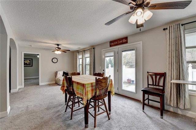 carpeted dining area featuring ceiling fan and a textured ceiling