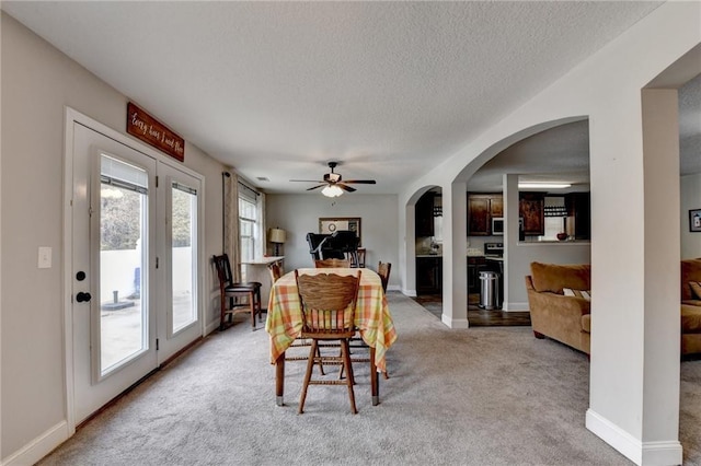 carpeted dining space featuring ceiling fan and a textured ceiling