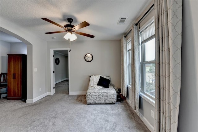 unfurnished room featuring ceiling fan, light carpet, and a textured ceiling