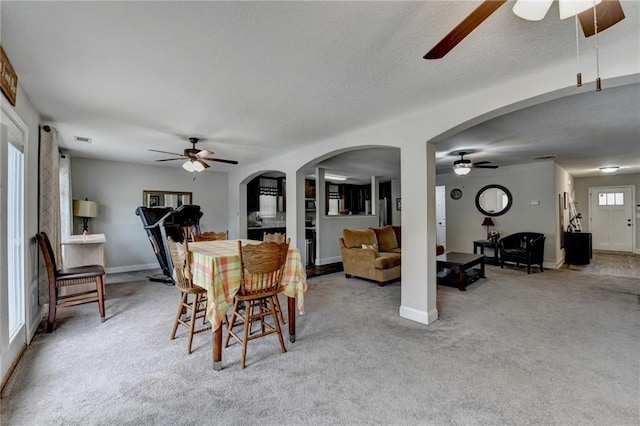 dining room featuring light carpet, ceiling fan, and a healthy amount of sunlight