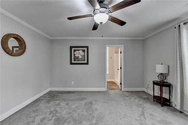 carpeted spare room featuring ceiling fan and ornamental molding