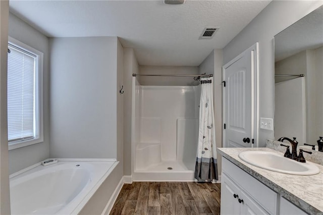 bathroom featuring walk in shower, vanity, a healthy amount of sunlight, and hardwood / wood-style flooring