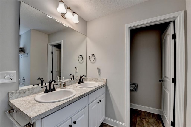 bathroom featuring vanity, a textured ceiling, and hardwood / wood-style flooring