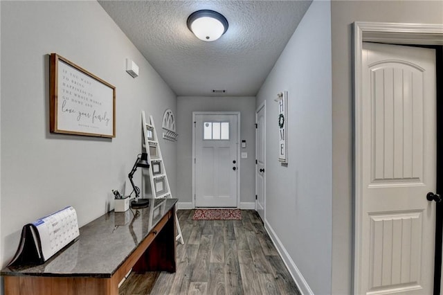 entryway with dark hardwood / wood-style flooring and a textured ceiling