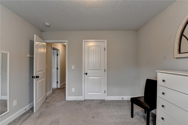 interior space with a textured ceiling and light carpet