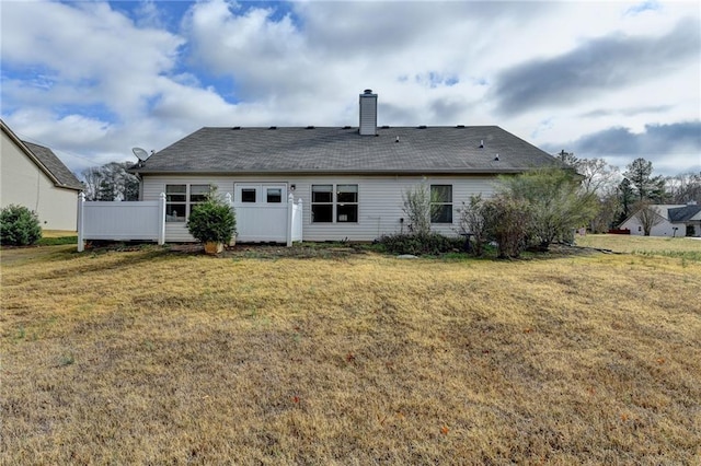 rear view of house featuring a lawn