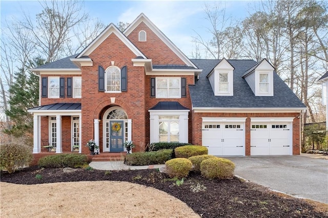 colonial home featuring a garage, brick siding, driveway, and roof with shingles