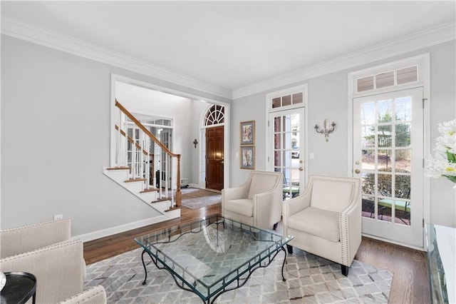 living area with plenty of natural light, stairway, and wood finished floors