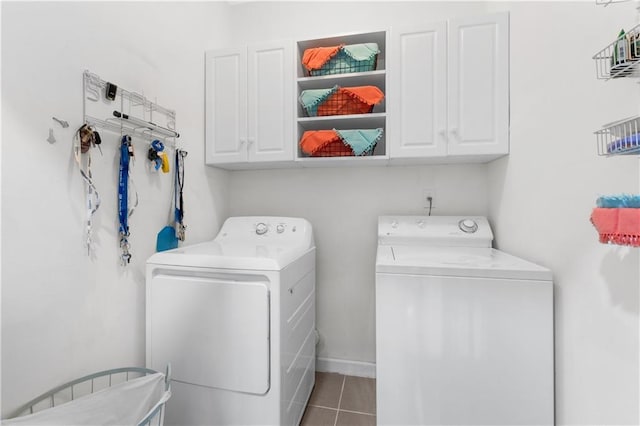 laundry area with cabinet space, independent washer and dryer, baseboards, and tile patterned floors