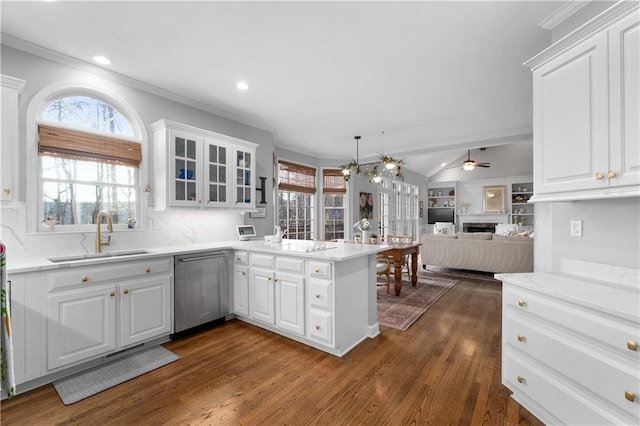 kitchen with stainless steel dishwasher, open floor plan, white cabinetry, a sink, and a peninsula