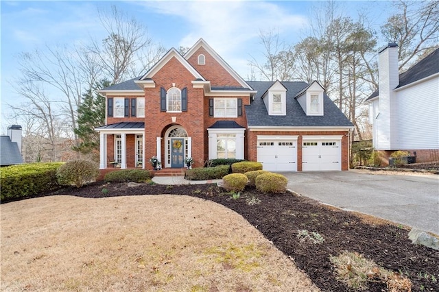 colonial-style house featuring a garage, concrete driveway, brick siding, and roof with shingles