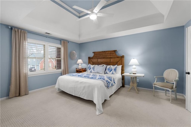 bedroom with carpet floors, a raised ceiling, and baseboards