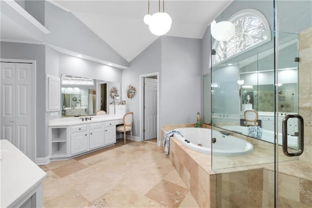 full bathroom featuring a closet, two vanities, a sink, a shower stall, and a bath