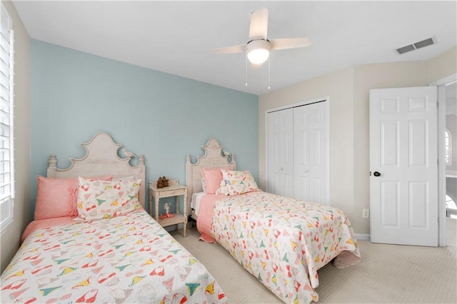 carpeted bedroom featuring a ceiling fan, baseboards, visible vents, and a closet