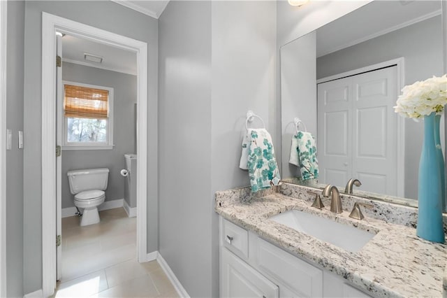 bathroom featuring crown molding, toilet, vanity, tile patterned flooring, and baseboards