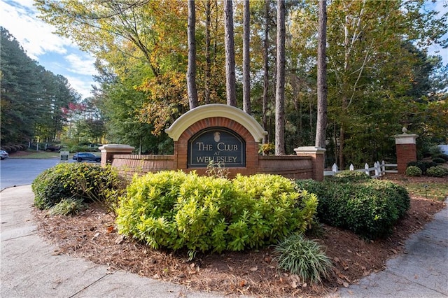 community / neighborhood sign featuring fence