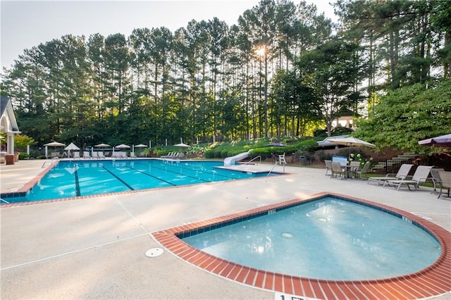 pool with a patio and a water slide