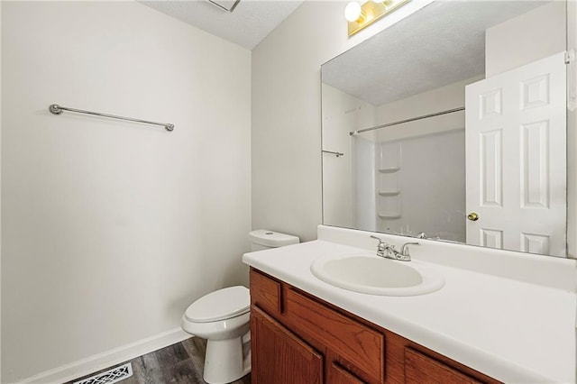 bathroom with visible vents, toilet, walk in shower, a textured ceiling, and vanity