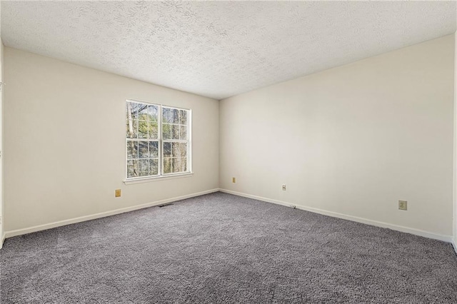 unfurnished room with carpet floors, visible vents, a textured ceiling, and baseboards