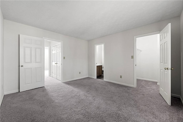 unfurnished bedroom featuring a textured ceiling, a closet, and carpet