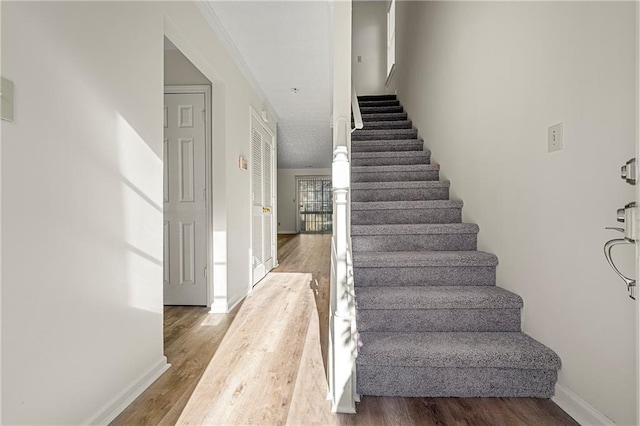 staircase with wood finished floors and baseboards