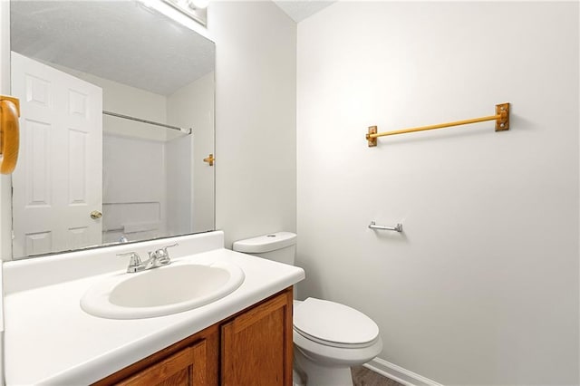 bathroom featuring a shower, vanity, and toilet