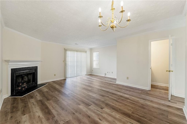 unfurnished living room featuring a fireplace with raised hearth, a textured ceiling, wood finished floors, baseboards, and ornamental molding