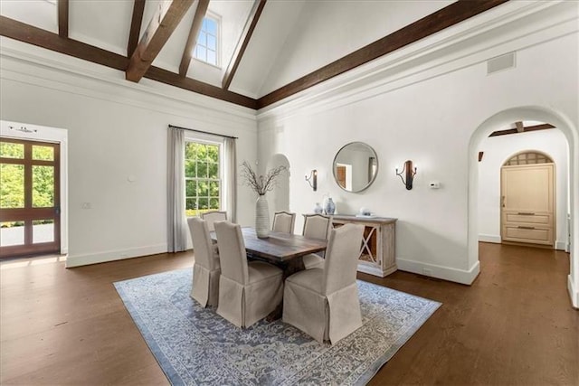 dining space featuring beamed ceiling, dark hardwood / wood-style flooring, and a towering ceiling