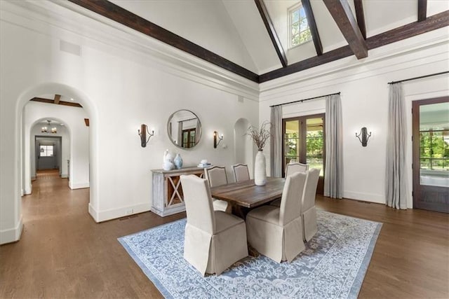 dining room with french doors, a towering ceiling, dark hardwood / wood-style floors, and beamed ceiling